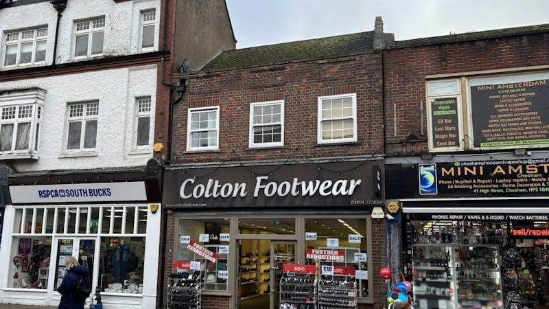 Street view of storefronts, including RSPCA South Bucks, Colton Footwear, and Mini Amsterdam, with sale signs in windows.