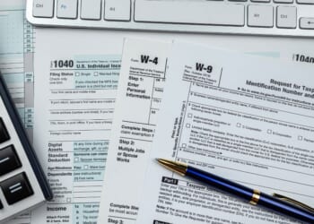 Blank tax forms sit on a desk.
