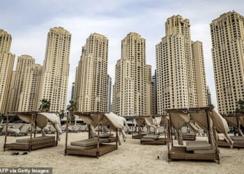 Empty beds in front of buildings along a beach at Jumeirah Beach Residence in Dubai