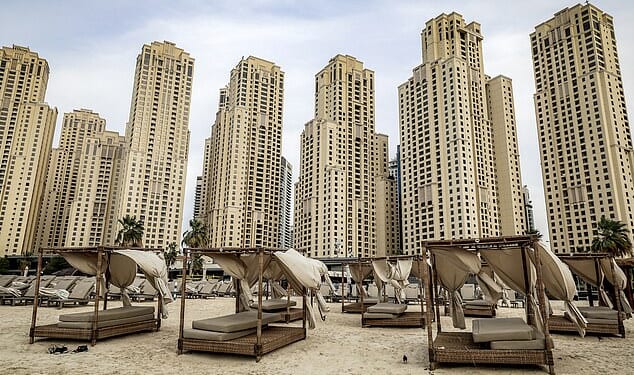 Empty beds in front of buildings along a beach at Jumeirah Beach Residence in Dubai
