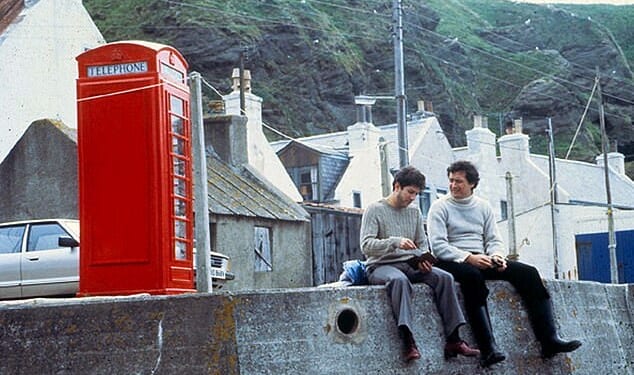 Mod con: Local Hero actors Peter Rieghert and Chris Rozycki sitting on the harbour wall by Pennan¿s famous red phone box, which still draws tourists to the village