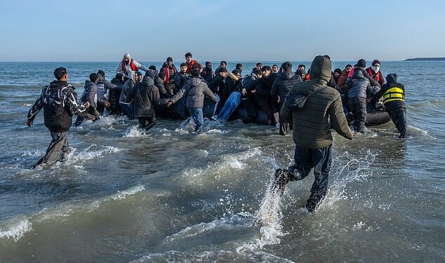 Migrants sprint through the surf at Gravelines beach in northern France last week to board a dinghy to Britain