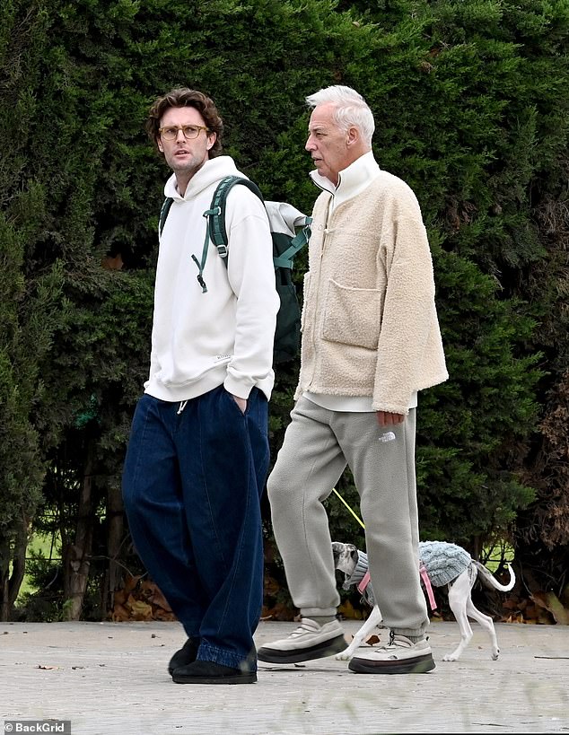 By his side is a male companion, who looked stylish in wide-leg jeans and a white hoodie as they took Michael's pet pooch Lara for a walk around the town of El Papiol close to Barcelona