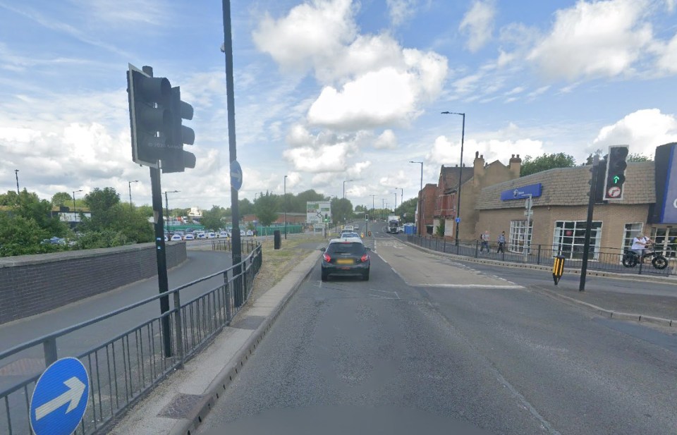 A street-level view of North Bridge Road in Doncaster, with traffic lights, commercial buildings, and parked cars.