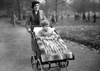 Then-Prince Charles is taken for a walk in his pram through the park on his third birthday by nanny Mabel Anderson