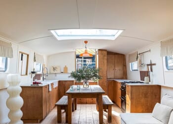 The boat’s main room features an open-plan kitchen and living room with a concealed snug at the other end that Rosanna opens up to enlarge the space. The kitchen is made from stained birch ply with cupboard handles from Etsy.