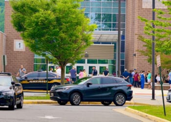 Parents, faculty, and students gather outside the main entrance of Fairfax High School after a 911 call was received from the school in Fairfax, Virginia, on June 6, 2023.