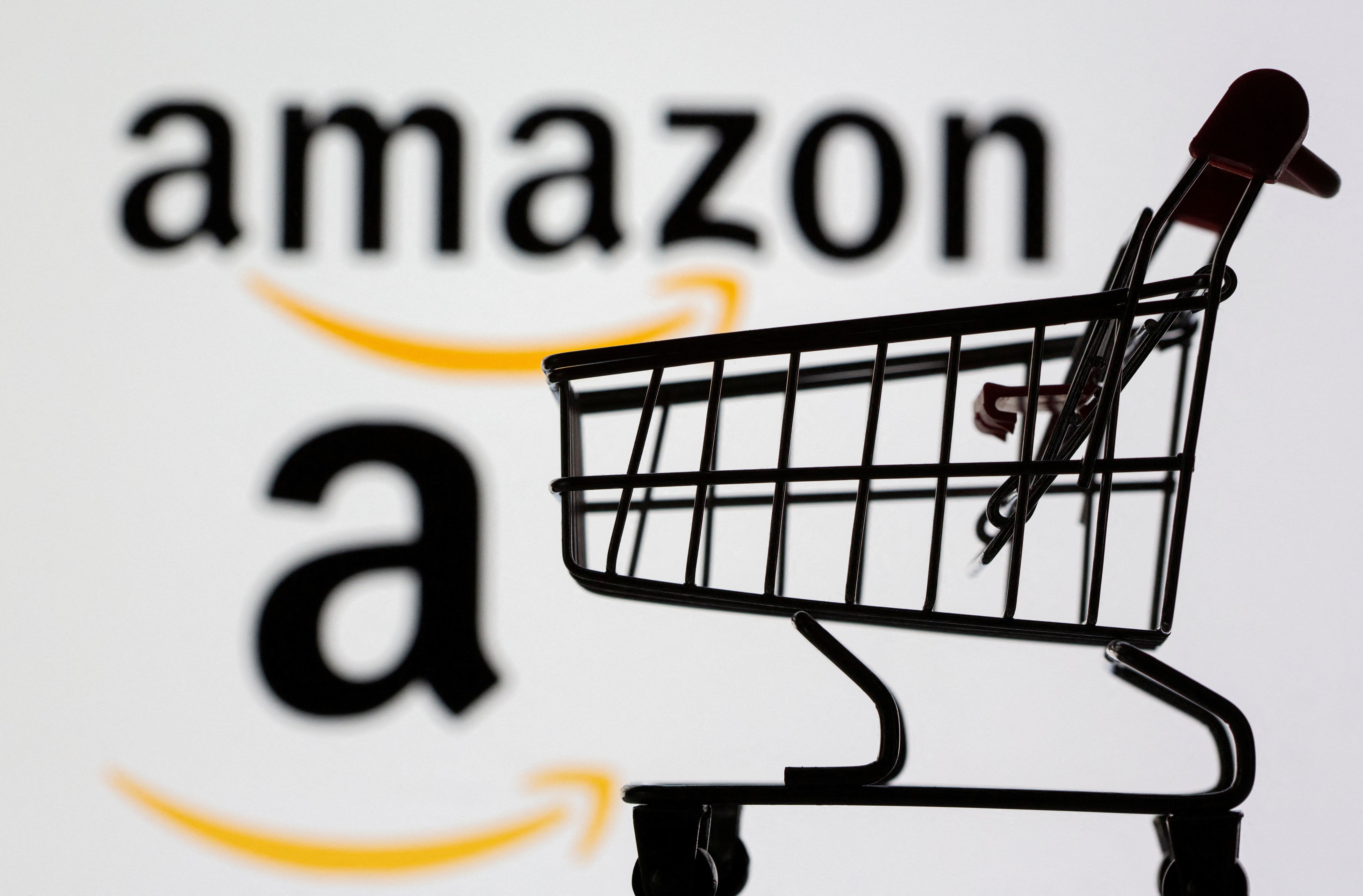 Illustration of a small shopping cart in front of a blurred Amazon logo.