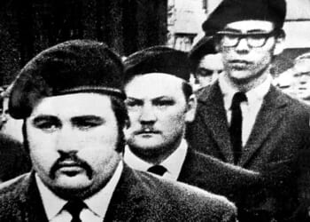 Gerry Adams (right) marches in a guard of honour' at the funeral of Provisional IRA man Michael Kane in Belfast in September 1971