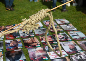 A woman holds a protest noose above photos of victims of Iranian executions on September 16, 2022.