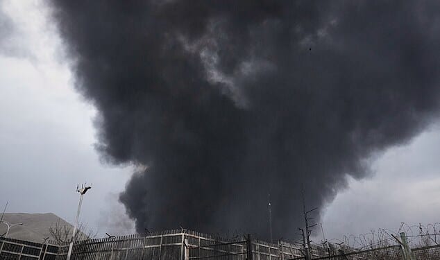 A thick plume of smoke rises from an oil storage facility hit by a US-Israeli strike late Saturday in Tehran, Iran, Sunday, March 8, 2026