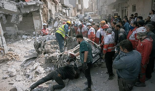 First responders inspect a destroyed car at the site of a residential building hit in an overnight strike during the US-Israeli military campaign in Tabriz, East Azerbaijan Province, northwestern Iran, Tuesday, March 24, 2026