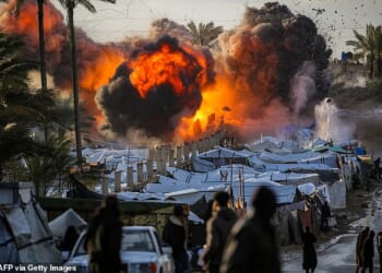 A fireball erupts following an Israeli strike near a tent encampment sheltering peope displaced by war in the central Gaza Strip on March 25