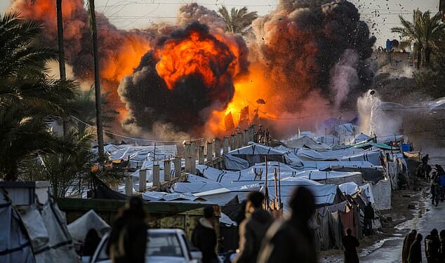 A fireball erupts following an Israeli strike near a tent encampment sheltering peope displaced by war in the central Gaza Strip on March 25
