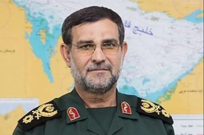 A bearded man in a military uniform with epaulets, against a blurred map background.