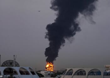 Flames and plumes of smoke pour upwards from a fuel tank near Dubai airport that was hit by shrapnel from an Iranian drone