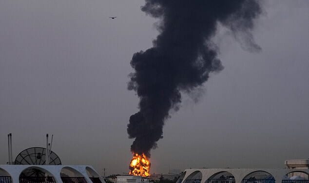 Flames and plumes of smoke pour upwards from a fuel tank near Dubai airport that was hit by shrapnel from an Iranian drone