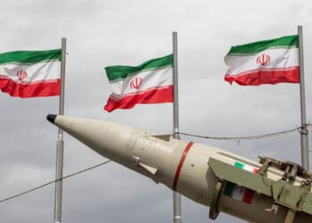 Iranian flags fly above missile during military demonstration in Tehran, Iran on Feb. 11, 2026.