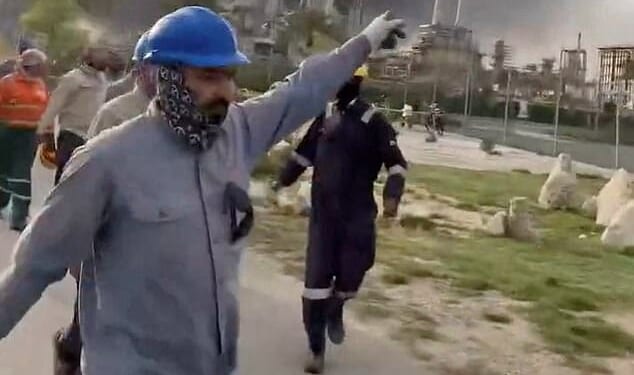 Pictured: Workers evacuate area around Saudi Aramco's Ras Tanura oil refinery as smoke rises following a reported Iranian drone strike
