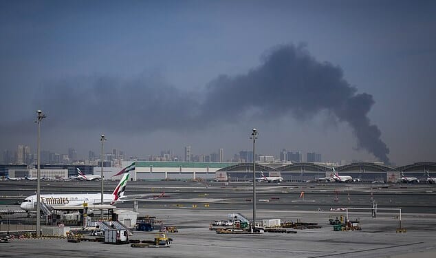 Smoke rises from Dubai International Airport on Sunday morning as Emirates planes remain grounded