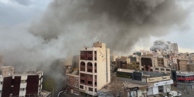 Plumes of smoke from two simultaneous strikes rise over Tehran, Iran, Monday. The attacks continued Tuesday with a reported strike on the city's airport.