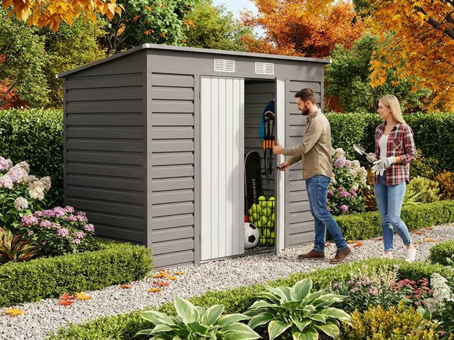 A man opening a grey steel garden shed filled with sports equipment, while a woman with gardening tools approaches.