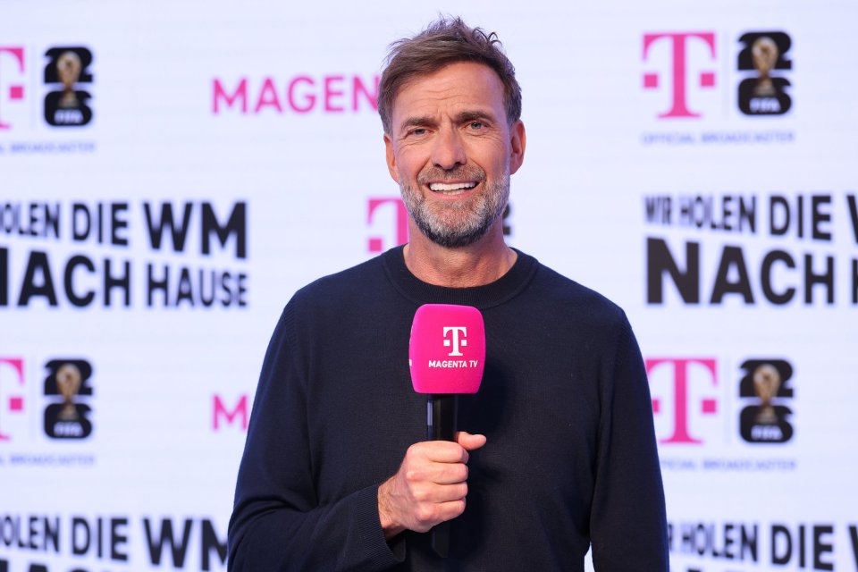 A man holding a MagentaTV microphone, with a "Telekom" logo and "FIFA World Cup 2026" branding in the background.