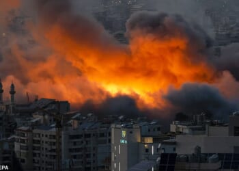 A classified intelligence report has concluded that it is unlikely the US will initiate regime change. The report was reportedly dated just a week before the military operation began. Pictured above is a suburb of Beirut after Israeli strikes