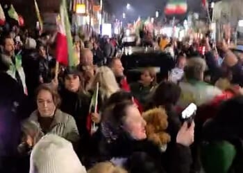 London street brought to a standstill as jubilant people blare music, hand out roses, and wave Iranian flags to celebrate the death of Ayatollah Ali Khamenei