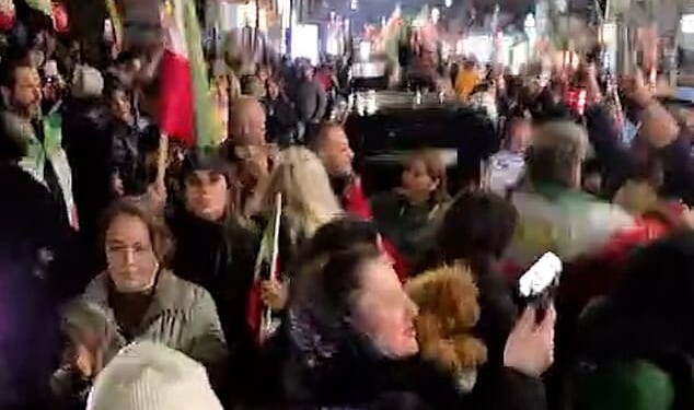 London street brought to a standstill as jubilant people blare music, hand out roses, and wave Iranian flags to celebrate the death of Ayatollah Ali Khamenei