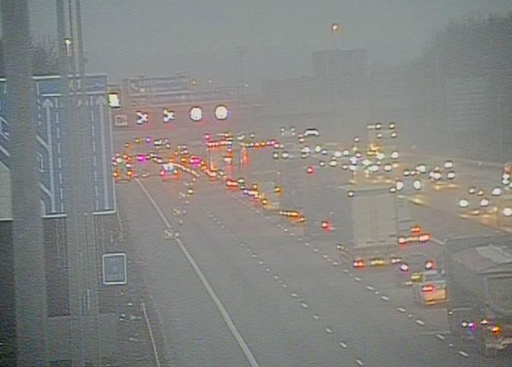 Traffic jam on a multi-lane highway in foggy conditions.