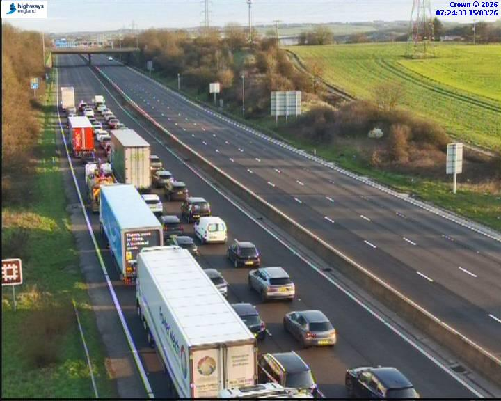 Heavy traffic on a multi-lane highway, with one side of the road completely clear and the other side congested with cars and trucks.