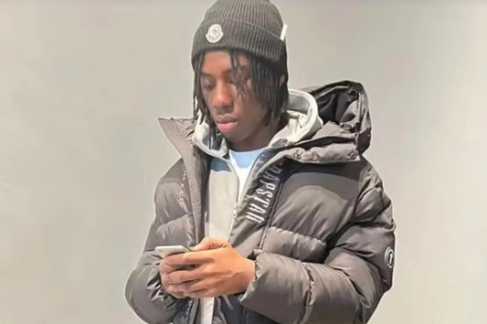 An image collage containing 1 images, Image 1 shows Tai Folkes looking at his phone