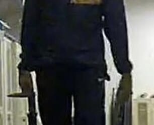 A man with a hat and face mask appears to be carrying objects out of the building on base