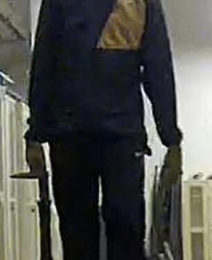 A man with a hat and face mask appears to be carrying objects out of the building on base