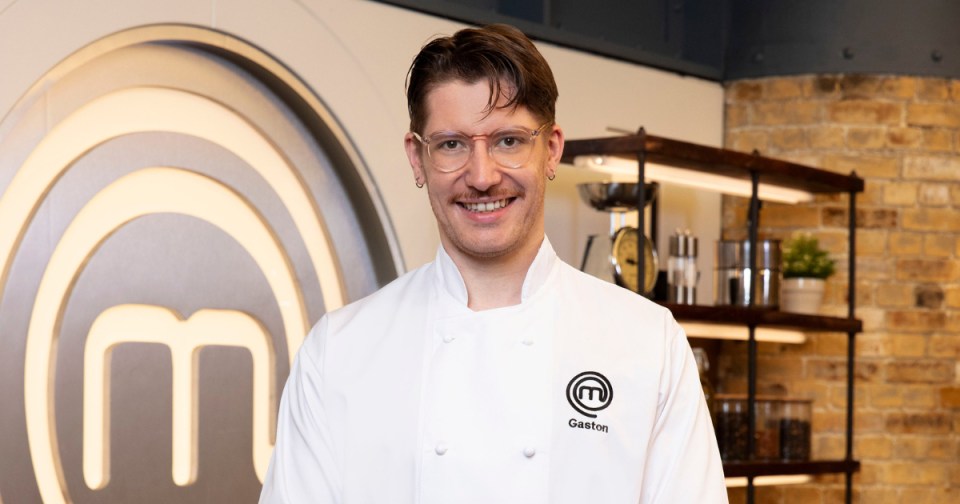 Gaston Savina, a MasterChef finalist, smiles while wearing a chef's jacket with his name and the MasterChef logo.