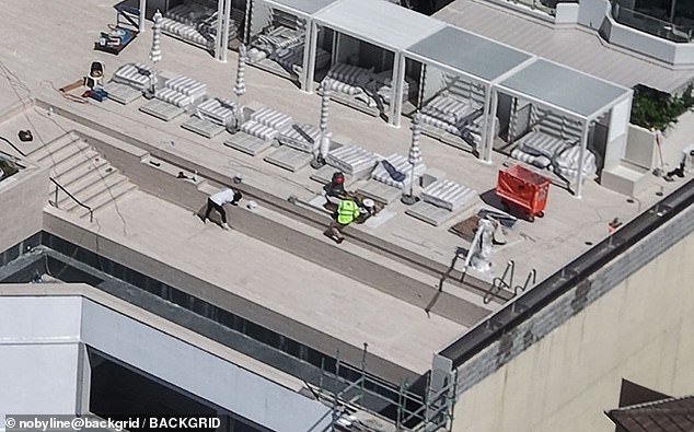 Staff work on the hotel's unfinished infinity pool at the hotel set to host the Duchess of Sussex next month