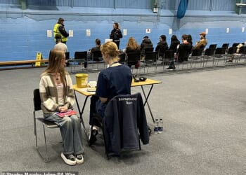 Students receiving vaccines and antibiotics from medical staff in the sports hall at the University of Kent campus in Canterbury