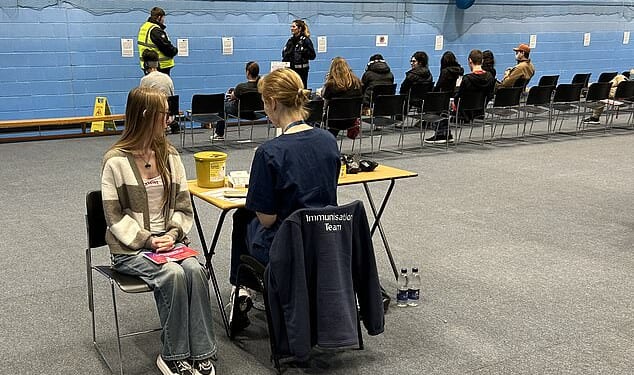 Students receiving vaccines and antibiotics from medical staff in the sports hall at the University of Kent campus in Canterbury