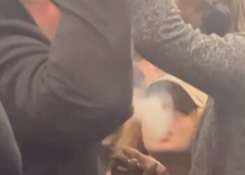 A vaping girl ignores the man's request for her to stop and instead exhales smoke towards him