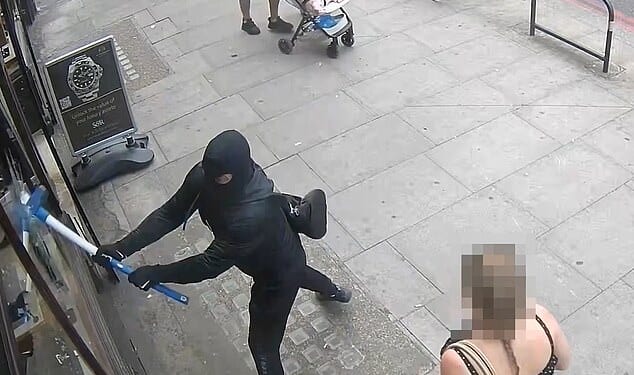Two thugs wearing balaclavas used sledgehammers to smash their way into a luxury shop on Edgeware Road in Westminster