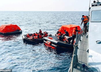 Sri Lanka Navy personnel assist Iranian sailors during a rescue operation after responding to a distress call from their vessel