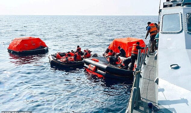 Sri Lanka Navy personnel assist Iranian sailors during a rescue operation after responding to a distress call from their vessel