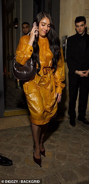 Madonna's daughter Lourdes Leon opted for an eye-catching orange trench coat and accessorised with a brown leather handbag