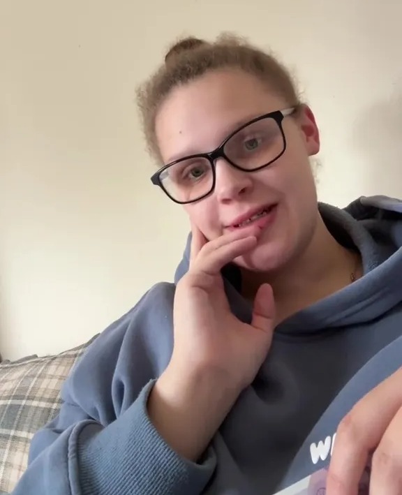 A pregnant woman in glasses looking at the camera, with text above her head indicating she has only £40 left and no electricity, food, or petrol.