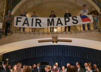 Activists display signs during a press conference inside the rotunda of the Missouri State Capitol Building on Sept. 10, 2025, in Jefferson City, Missouri.