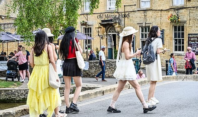 A group of women walk near picturesque buildings in Bourton-on-the-Water in summer last year