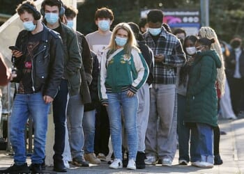 Students wait in line at the entrance to the sports hall at the University of Kent, where the rollout of a meningitis B vaccine to about 5,000 students began on Wednesday