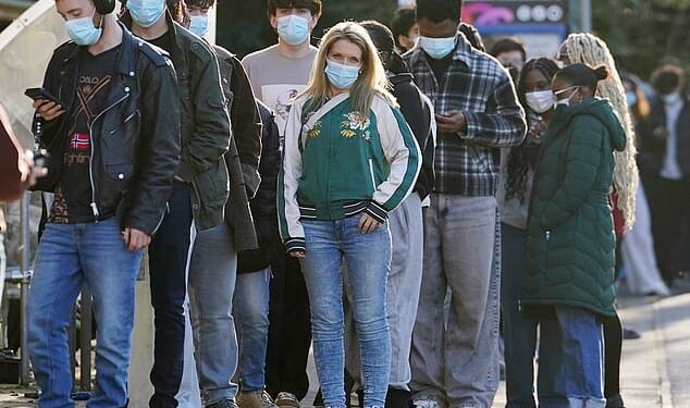 Students wait in line at the entrance to the sports hall at the University of Kent, where the rollout of a meningitis B vaccine to about 5,000 students began on Wednesday