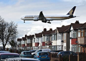 Pictured: A plane flies low over homes in south London on its approach to Heathrow Airport. Postcodes in Southall and Staines were ranked among the worst affected